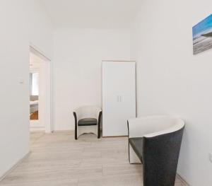 a white room with two chairs and a mirror at Elite Apartment MZ in Vienna