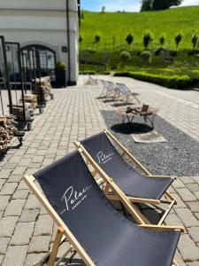 - une rangée de chaises longues assises sur une terrasse dans l'établissement Hotel Pałac Jugowice, à Wałbrzych
