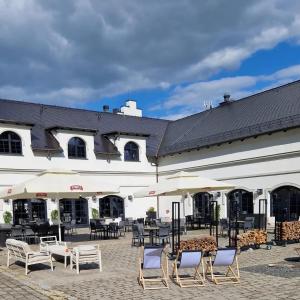 un groupe de chaises et de tables devant un bâtiment dans l'établissement Hotel Pałac Jugowice, à Wałbrzych