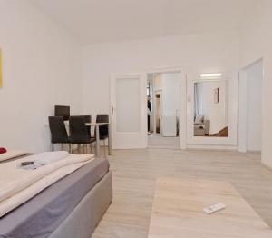a white room with a bed and a table and chairs at Elite Apartment MZ in Vienna