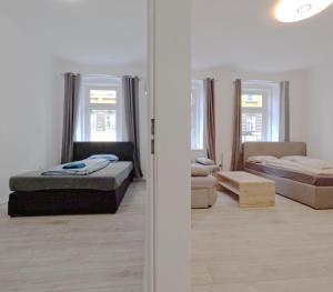 a white room with two beds and a couch at Elite Apartment MZ in Vienna