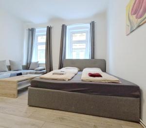 a bedroom with two beds and a couch at Elite Apartment MZ in Vienna
