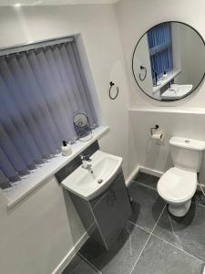 a bathroom with a toilet and a sink and a mirror at Anfield - Stylish four-bedroom Victorian house in Liverpool