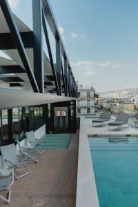 szereg krzeseł i basen w budynku w obiekcie Plexi Space w Atenach