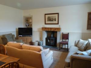 sala de estar con sofás y chimenea en The Bothy, Gallin, Glenlyon, Perthshire, en Bridge of Balgie