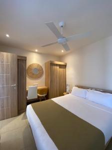 - une chambre avec un grand lit et un ventilateur de plafond dans l'établissement VILLA LILOU, Splendide villa au centre de Grand Baie, à Grand Baie