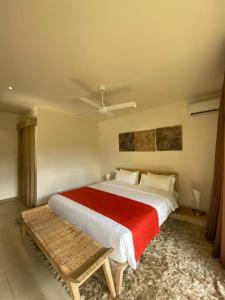 - une chambre avec un grand lit et une couverture rouge dans l'établissement VILLA LILOU, Splendide villa au centre de Grand Baie, à Grand Baie