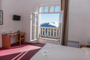 a room with a bed and a desk and a window at Villages Clubs du Soleil - SUPERBAGNERES in Superbagnères