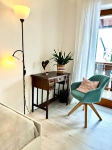 sypialnia z biurkiem, zielonym krzesłem i lampką w obiekcie Privatzimmer Hanna w mieście Dießen am Ammersee