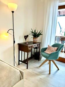 a bedroom with a desk and a green chair and a lamp at Privatzimmer Hanna in Dießen am Ammersee