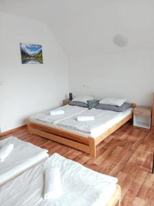 two beds in a room with wooden floors at ALMI - penzion - pizzerie in Staré Splavy