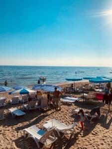 a group of people on a beach with chairs and umbrellas at Divine Beach Resort Kumburgaz in Buyukcekmece