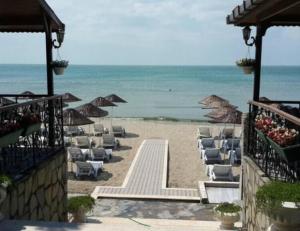 a beach with lounge chairs and umbrellas and the ocean at Divine Beach Resort Kumburgaz in Büyükçekmece