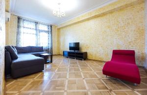 sala de estar con sofá y TV en Apartment Arena City 911 en Kiev