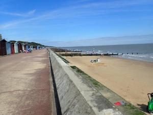 a beach with people on the sand and the ocean at Walton House in Frinton-on-Sea