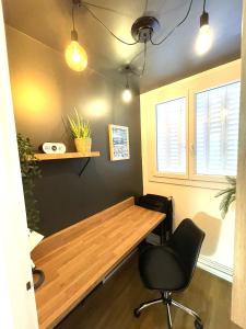 a room with a wooden table and a chair at LAppart de Gauche Confort en ville avec parking privé in Le Creusot