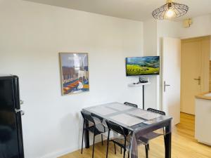 a kitchen with a table and chairs in a room at L'appart de Gauche in Le Creusot