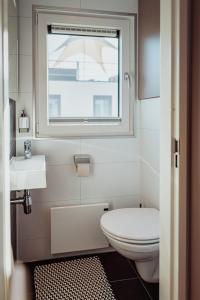 a bathroom with a toilet and a sink and a window at Schwimmendes Ferienhaus Cosy Home - Spreewald in Laasow