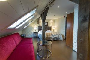 ベルゲンにあるデット ハンザティスク ホテルのベッド1台、ソファ、窓が備わる客室です。