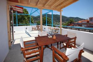 a wooden table and chairs on a balcony at Aktaion Guest Rooms in Skopelos Town