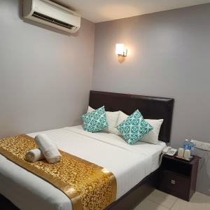 1 dormitorio con 1 cama con almohadas azules y blancas en Royale City Hotel - 10 min from KLIA KLIA 2 Airport en Sepang