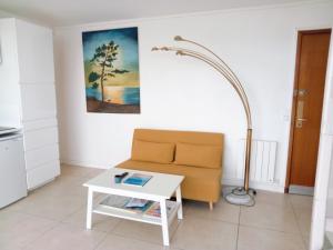 a living room with a couch and a table at T1 bis neuf avec petite chambre à 150m de la plage in La Baule +10 photos