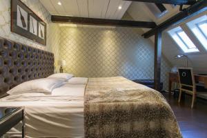 a bedroom with a large bed and a window at Det Hanseatiske Hotel in Bergen