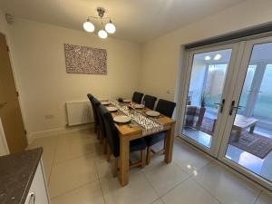 a dining room with a table and chairs at 3 Bed Home for Contractors Relocators with Parking Garden WiFi Sleeps 6 in Milton Keynes