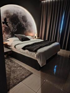 a bedroom with a large bed with a moon backdrop at Star Room in Ras al Khaimah