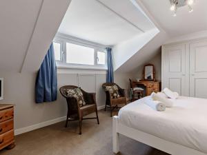 a bedroom with a bed and two chairs at 1 Bed in Brixham BX044 in Brixham