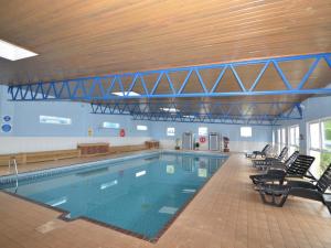 a large swimming pool with chairs in a building at 2 Bed in Brixham BX081 in Brixham