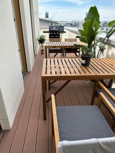 un ponte di legno con tavoli e panche su un balcone di Moderne Penthousewohnung in Zentrumsnähe a Lipsia