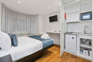 małą sypialnię z łóżkiem i kuchnią w obiekcie Private Studio Flat w Londynie
