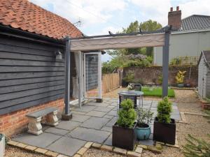 a pergola with a bench on a patio at 1 bed property in Mattishall 57021 in Mattishall