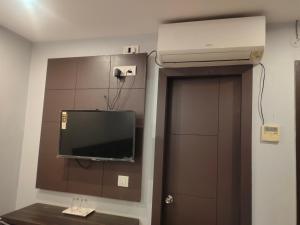 a room with a tv on the wall and a door at HOTEL IMF in Patna