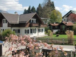 a house with pink flowers in front of a fence at Ferienhaus Waxenstein in Garmisch-Partenkirchen