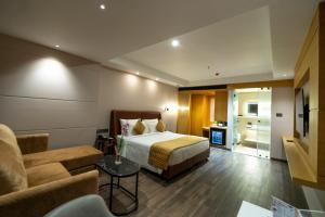 a hotel room with a bed and a couch at Regenta Inn Bhavani Nellore By Royal Orchid Hotels in Nellore
