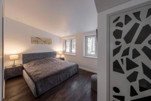 1 dormitorio con 1 cama y 2 ventanas en Bravo Apartments, en Kaunas