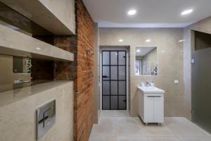 ein Badezimmer mit Waschbecken und einer Ziegelwand in der Unterkunft Bravo Apartments in Kaunas