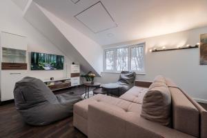 ein Wohnzimmer mit Sofa und Fernseher in der Unterkunft Bravo Apartments in Kaunas