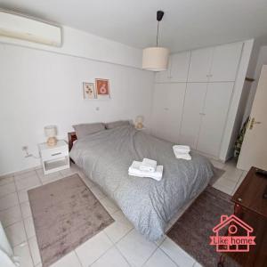 una camera da letto con un letto e due asciugamani di Like home Διαμέρισμα κοντά στο ΤΕΙ και στο κέντρο a Lamía
