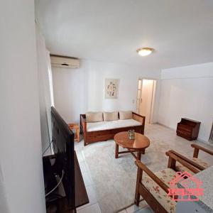 uma sala de estar com um sofá e uma televisão em Like home Διαμέρισμα κοντά στο ΤΕΙ και στο κέντρο em Lamía