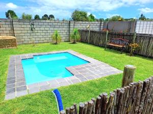 a small swimming pool in a yard with a fence at Theescombe Accomodation in Port Elizabeth