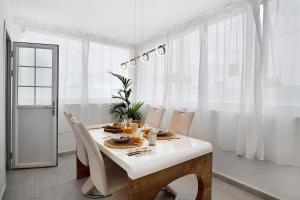 a white dining room with a table and chairs at Villa Khaleesi in Playa Blanca