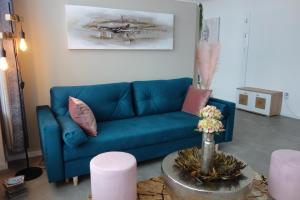 a living room with a blue couch and a table at Ferienwohnung Solling Niedersachsen in Uslar