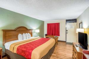 a hotel room with a bed and a television at Econo Lodge Huntington - Barboursville University Area in Huntington