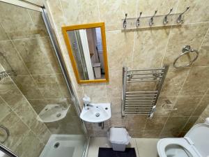 a bathroom with a shower and a sink and a toilet at 4 Bedrooms, 2 Bathrooms, Parking, Spacious House in London
