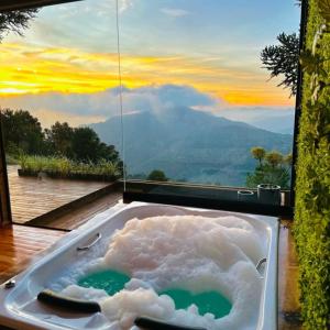 a jacuzzi tub with a view of the mountains at Pousada Flocos de Neve in Urubici