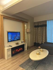 sala de estar con chimenea y TV en Bof Hotels Ceo Suites Atasehir, en Estambul