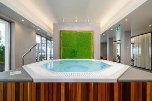 a hot tub in a room with a green wall at Apartments in the Centre of Zakopane Szymony by Renters in Zakopane